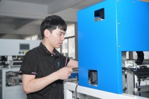 Technician Performing Maintenance on Automatic Carton Folding Machine in Factory Workshop